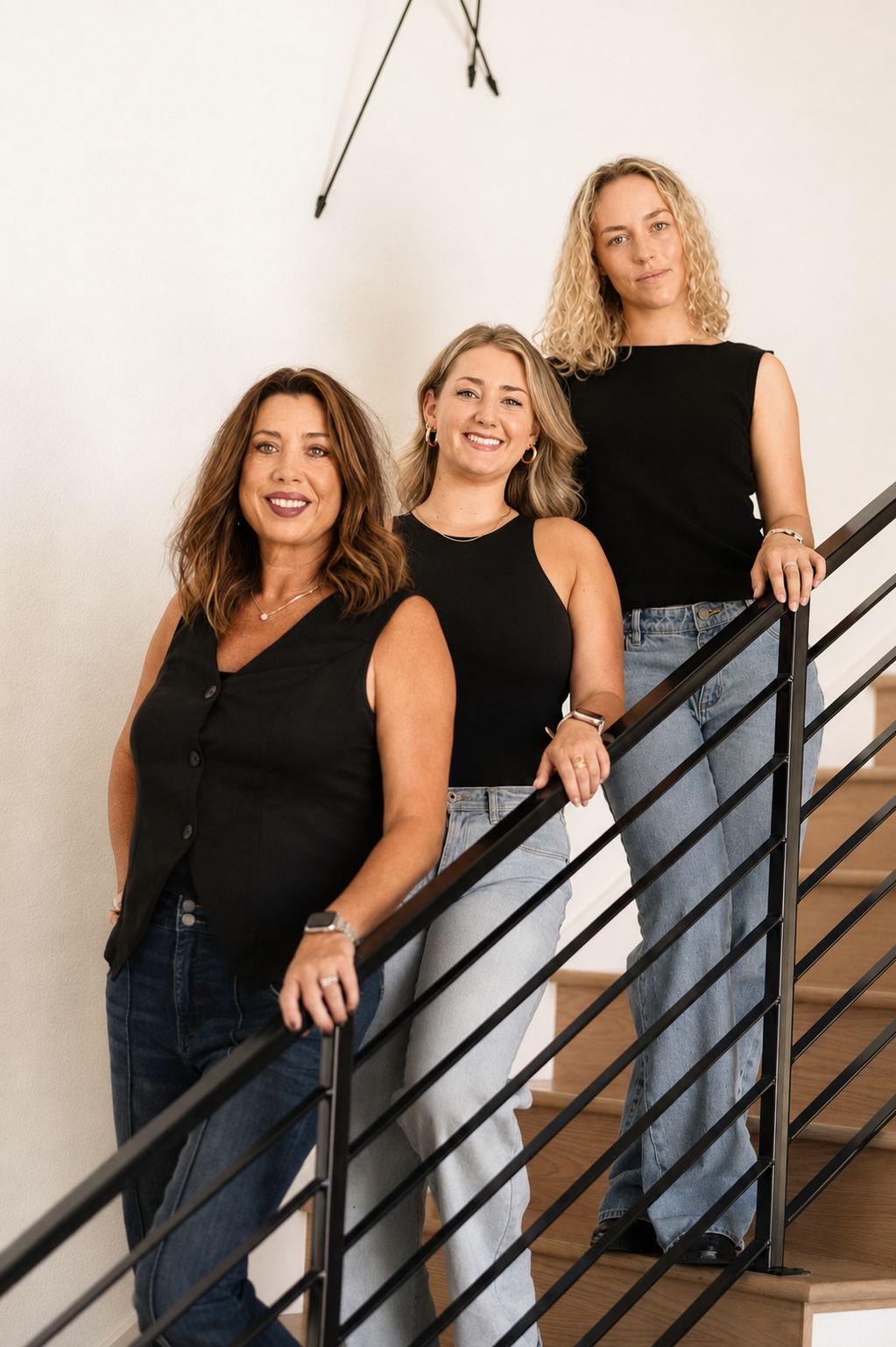 The SELLITSTAGED team on a modern staircase with a black wire railing